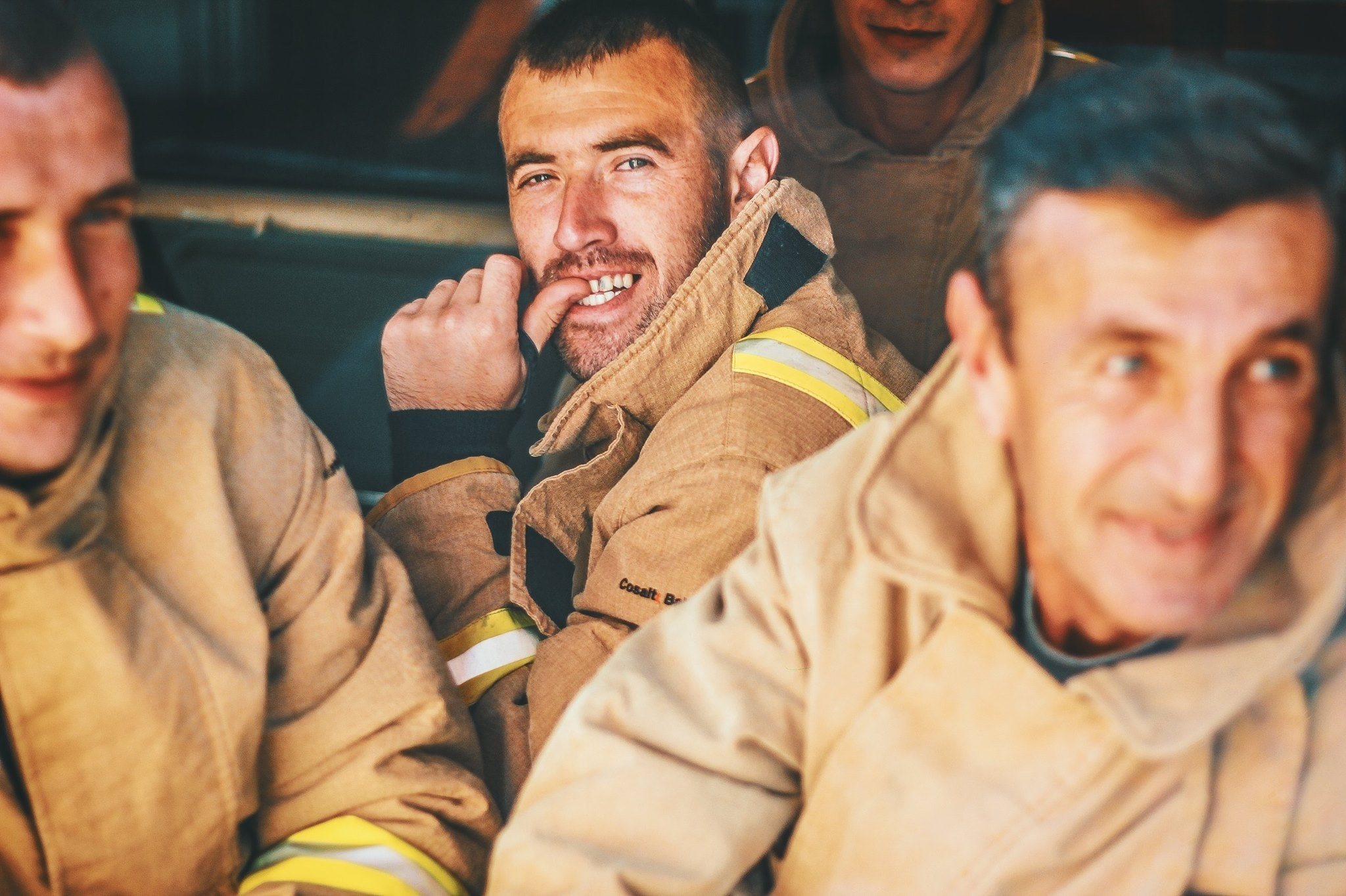 Firefighters laughing in the back of a truck