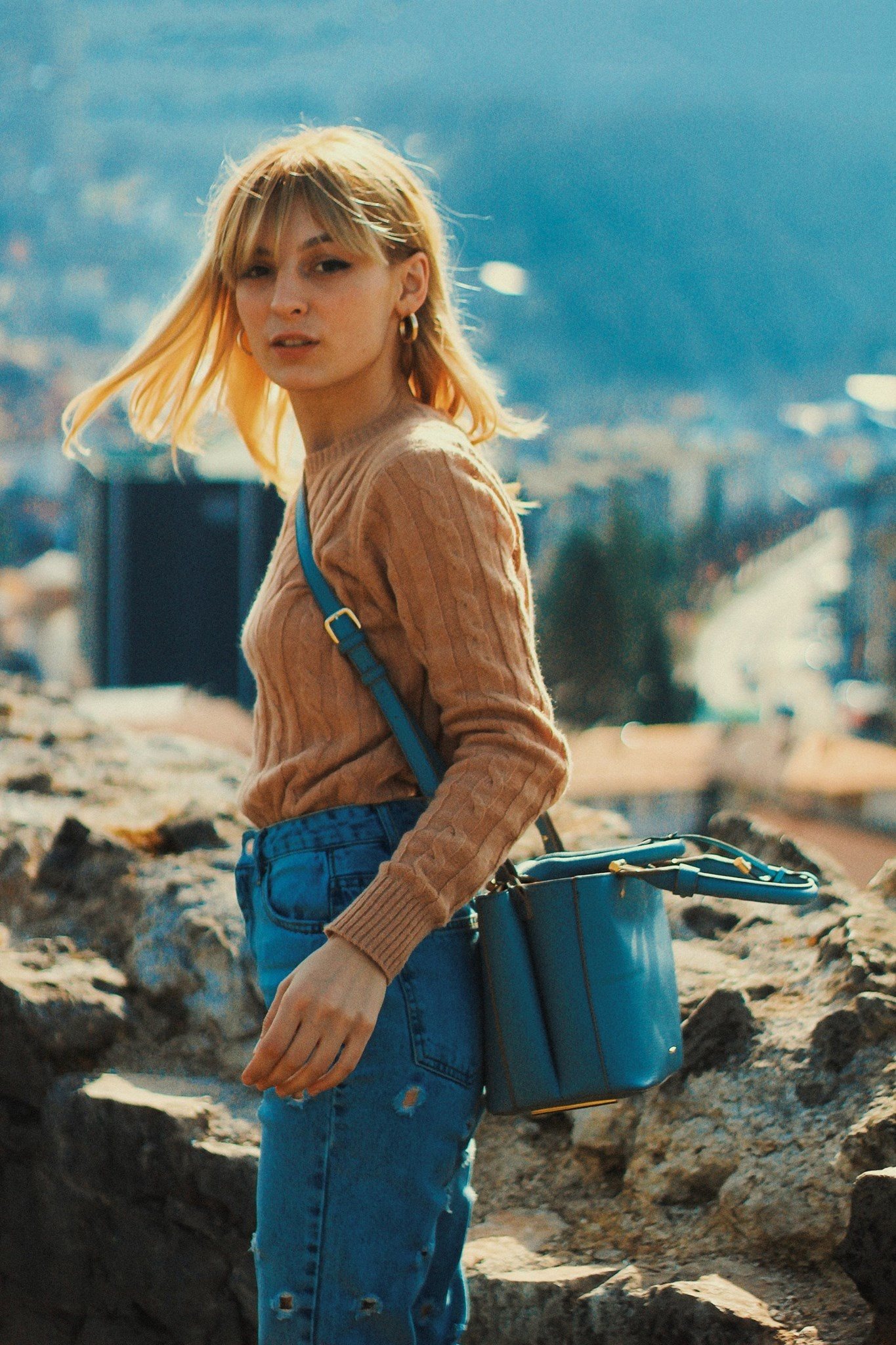 Woman with a blue bag, mountains behind