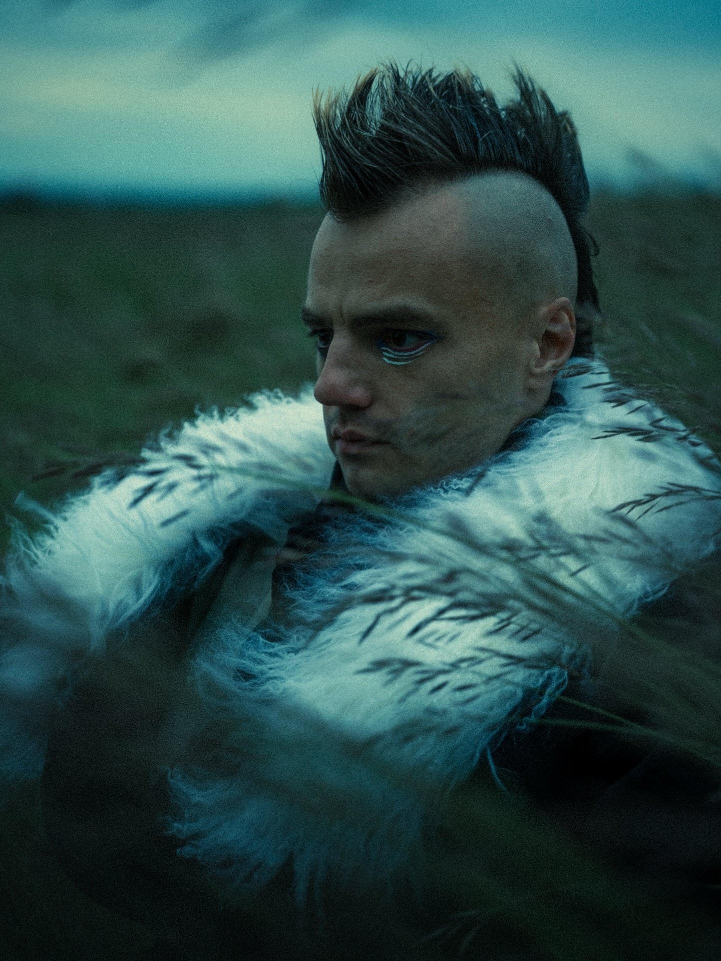 Portrait — mohawk and fur collar in tall grass