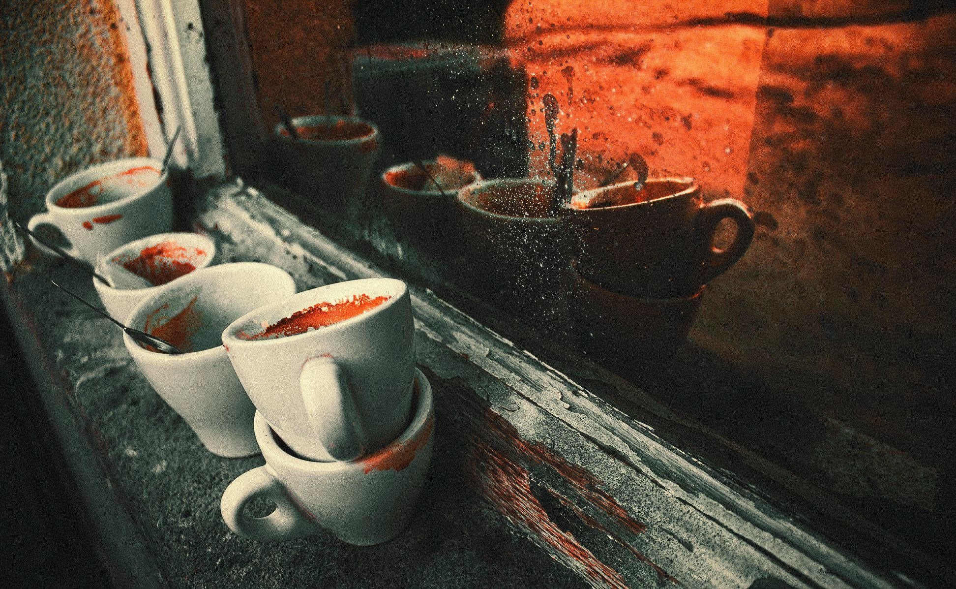 Espresso cups on a window sill at sunset