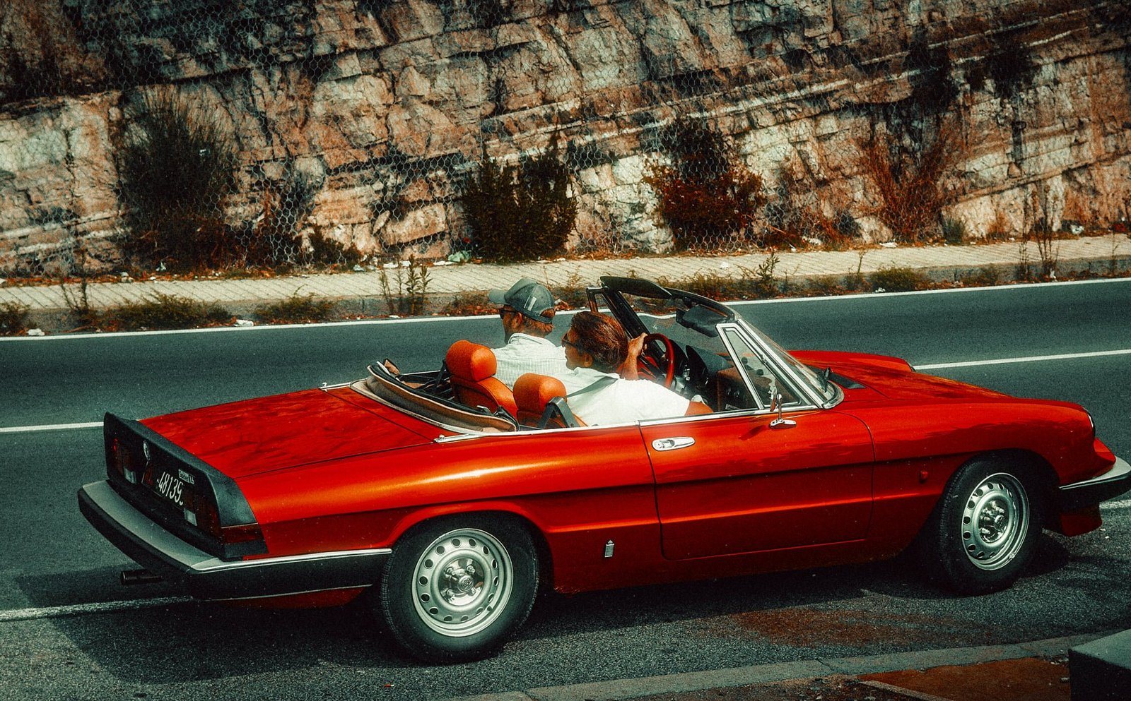 Red Alfa Romeo Spider on a coastal road