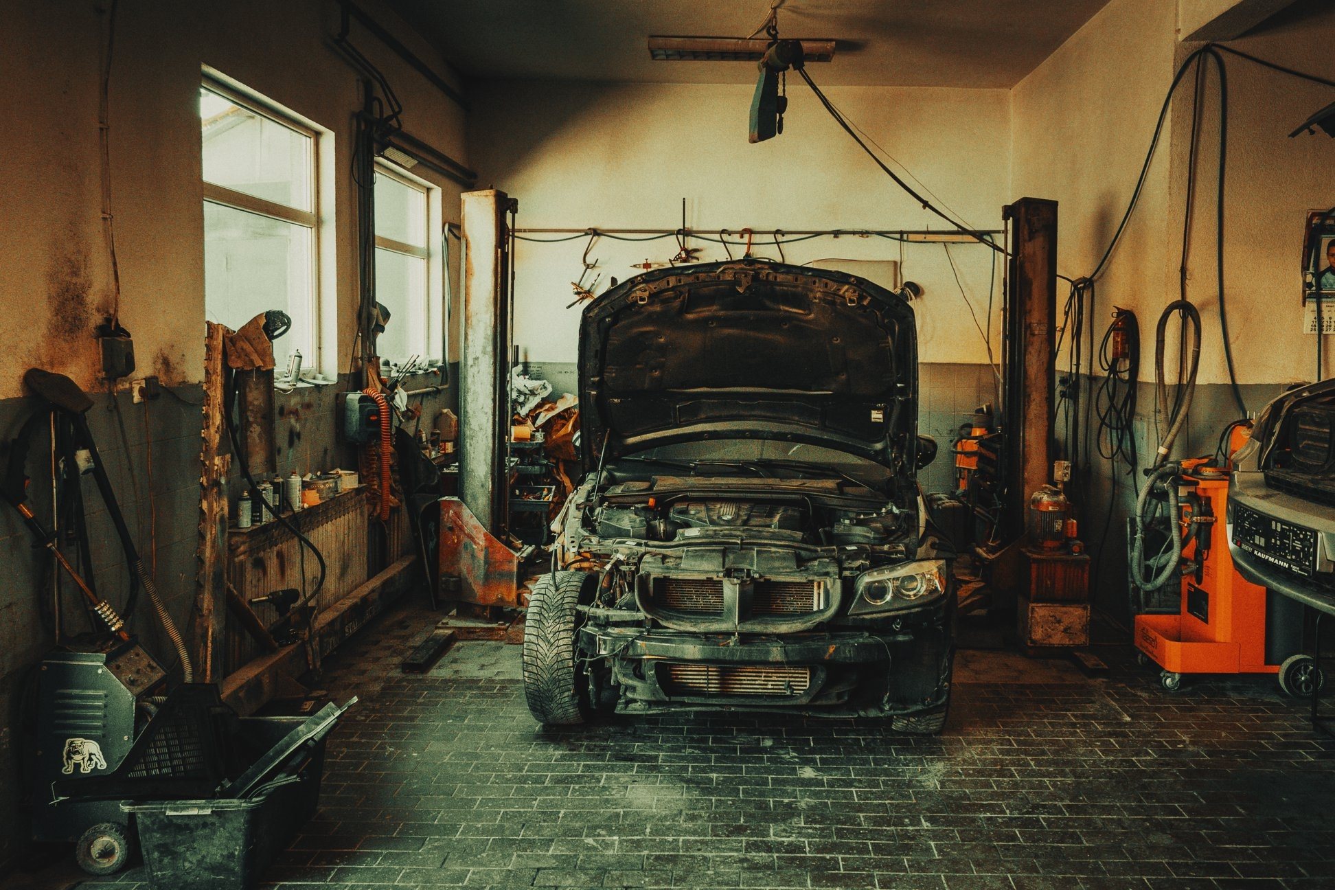 Car with open hood in a warm-lit garage