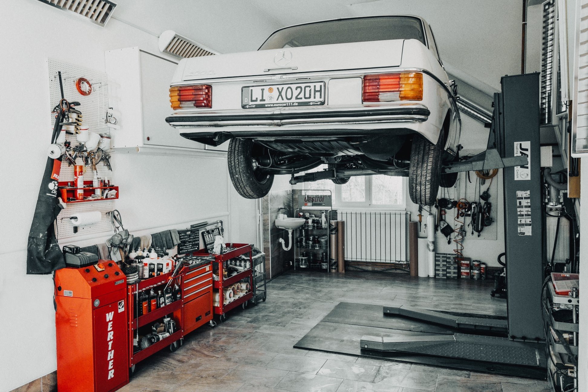 White Mercedes on a lift in a clean garage