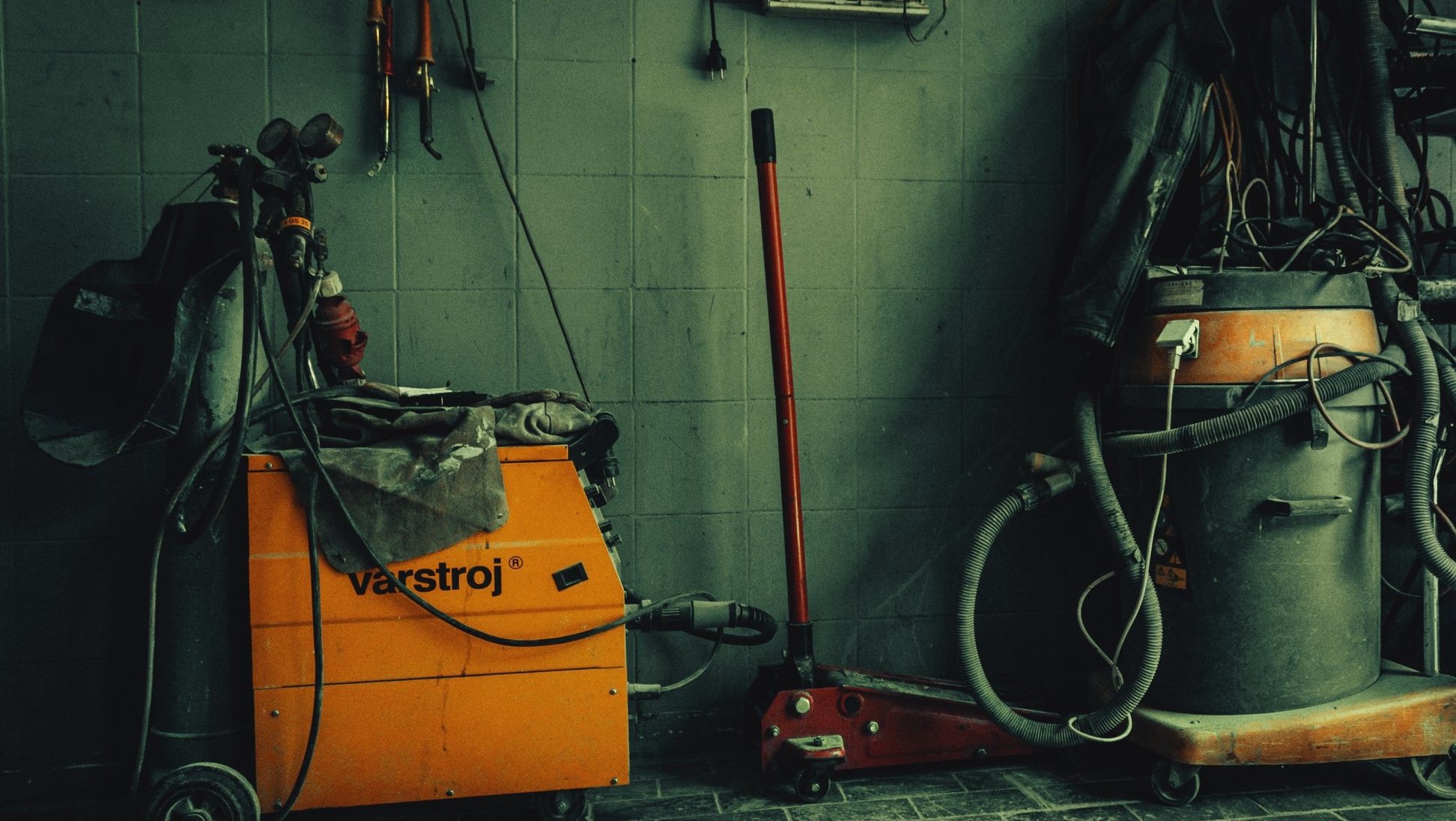 Welding rig against green tiles